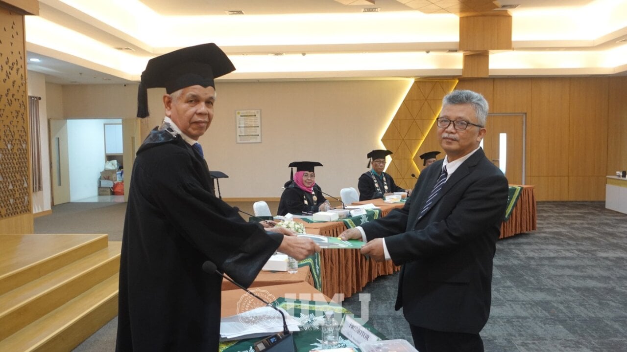 Promotor Prof. Dr. Armai Arief, M.Ag., (kiri) menyerahkan tanda kelulusan kepada Imam Mutjaba, (kanan) sebagai Doktor Ilmu Manajemen Pendidikan Islam seusai Sidang Terbuka di Aula Fakultas Kesehatan Masyarakat, Selasa (23/07/2024).