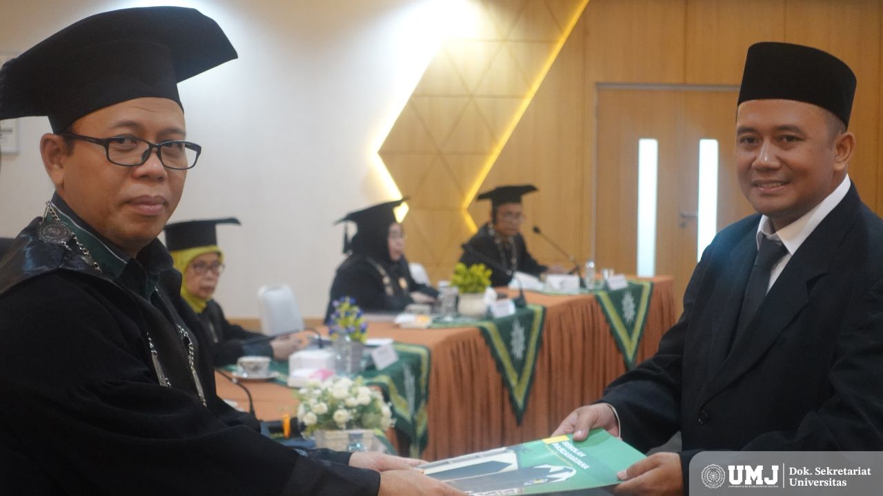 Dosen UMJ sekaligus Promotor Prof. Dr. Gofur Ahmad, MM. (kiri) menyerahkan tanda kelulusan kepada Hariyadi di Aula Fakultas Kesehatan Masyarakat, Kamis (24/10/2024). (Foto : KSU/Qithfirul Fahmi)
