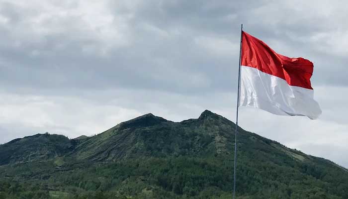 Bendera Merah Putih sedang berkibar didepan pegunungan (foto diambil dari https://www.islampos.com)