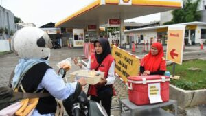 Petugas SPBU Shell menjajakan makanan dan minuman kepada pengendara motor sembari menunggu pasokan BBM di SPBU Shell Jalan Margonda Raya, Depok, Jawa Barat (Foto : antaranews.com)